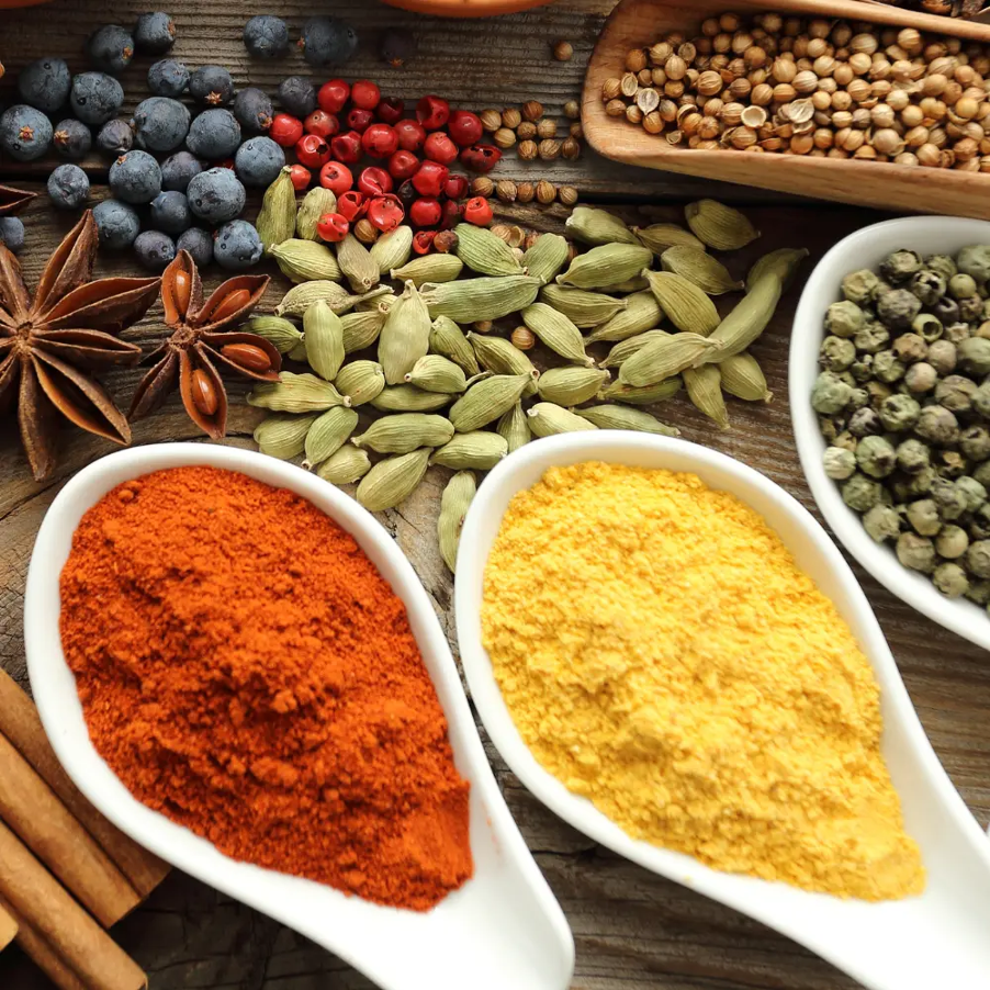 Spoons of paprika and turmeric with whole spices